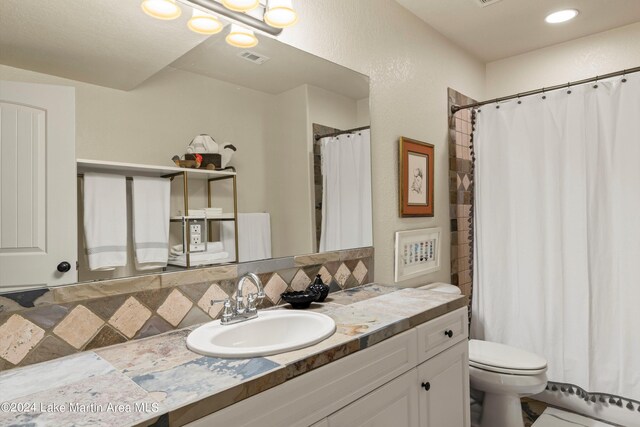 bathroom with tasteful backsplash, vanity, and toilet