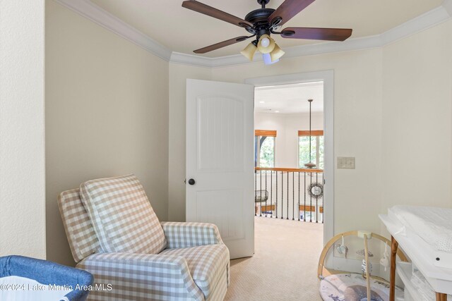 living area with crown molding and light colored carpet