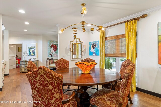 dining room with ornamental molding and light hardwood / wood-style flooring