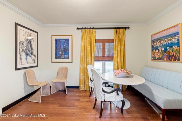 dining area featuring breakfast area, crown molding, and wood-type flooring