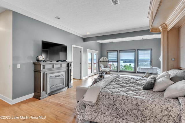 bedroom with hardwood / wood-style flooring, ornamental molding, a textured ceiling, access to outside, and french doors