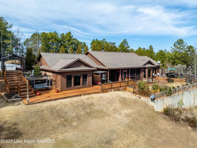 back of house featuring a hot tub and a deck