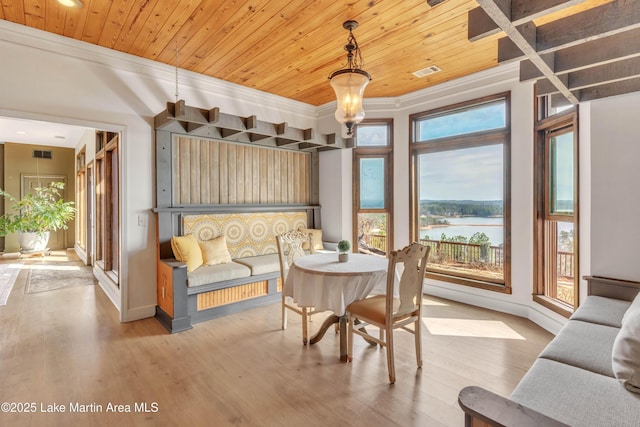 dining area featuring a water view, ornamental molding, wood ceiling, and hardwood / wood-style flooring