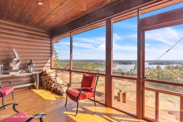 sunroom with wood ceiling and a water view