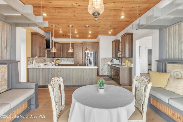 dining area featuring wood ceiling, crown molding, sink, and light wood-type flooring