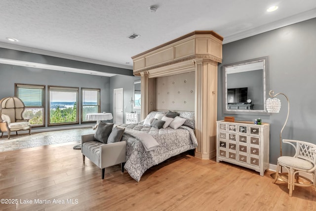 bedroom with crown molding, light hardwood / wood-style floors, and a textured ceiling