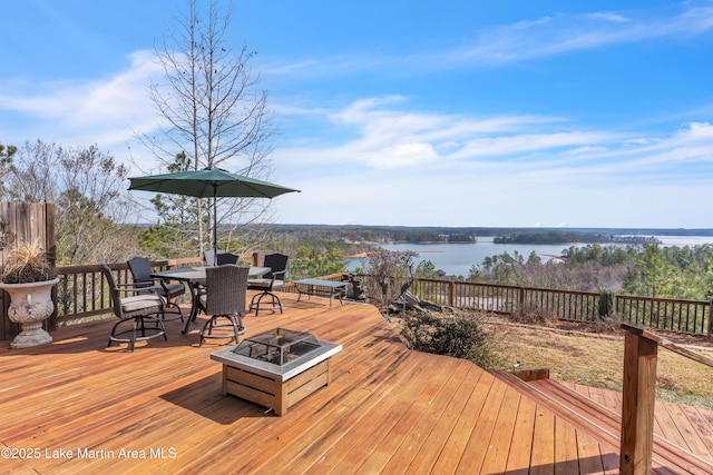 wooden deck with a water view and a fire pit