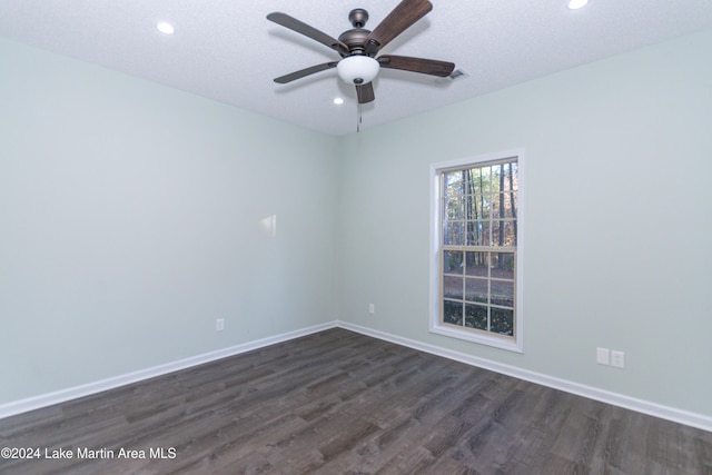 spare room featuring a textured ceiling, ceiling fan, and dark wood-type flooring