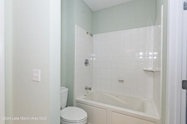 bathroom with toilet and tiled shower / bath