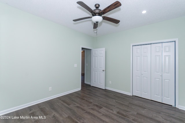 unfurnished bedroom featuring a textured ceiling, dark hardwood / wood-style flooring, a closet, and ceiling fan