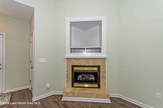 unfurnished living room with a tile fireplace and dark hardwood / wood-style flooring