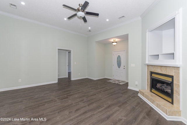 unfurnished living room with a tile fireplace, dark hardwood / wood-style floors, ceiling fan, and crown molding