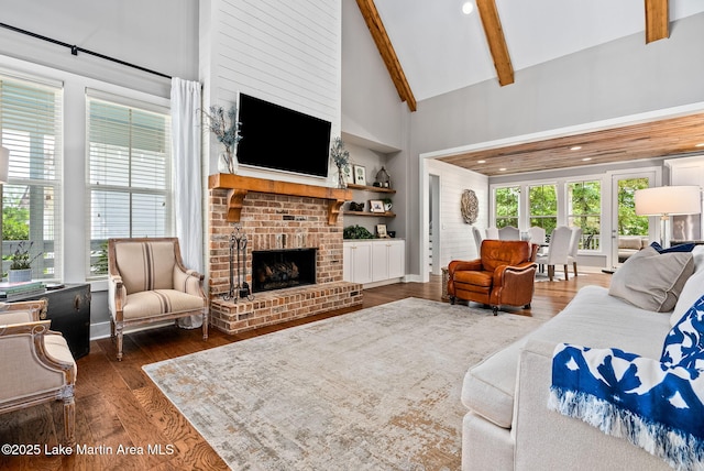 living room with beamed ceiling, dark hardwood / wood-style floors, a fireplace, and high vaulted ceiling