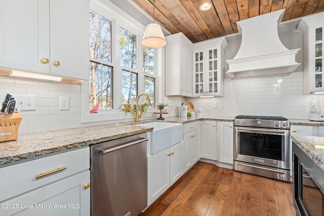 kitchen featuring backsplash, custom exhaust hood, stainless steel appliances, wooden ceiling, and white cabinetry