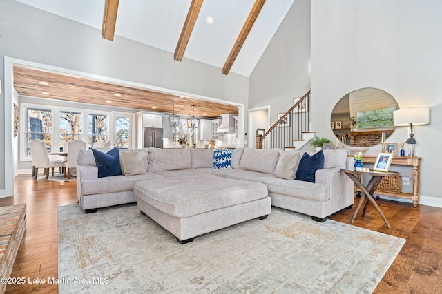 living room featuring hardwood / wood-style floors, beamed ceiling, and high vaulted ceiling