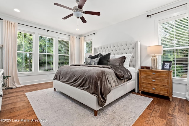 bedroom with multiple windows, ceiling fan, and dark wood-type flooring