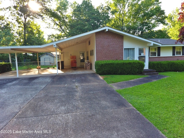 240 Windsor Dr, Alexander City, AL 35010 - view of front of home with a front lawn, brick siding, asphalt driveway, and an attached carport