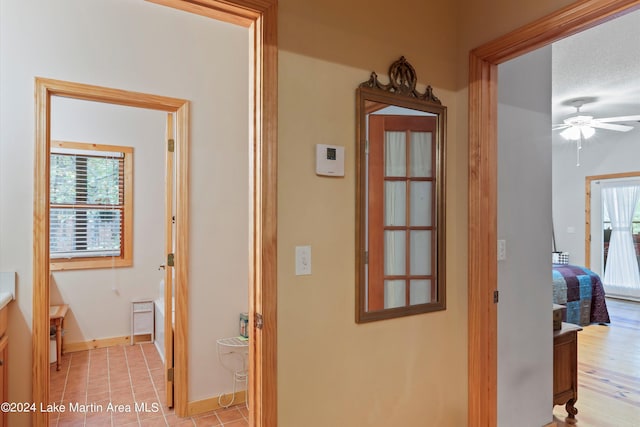 hall with light tile patterned floors and a textured ceiling