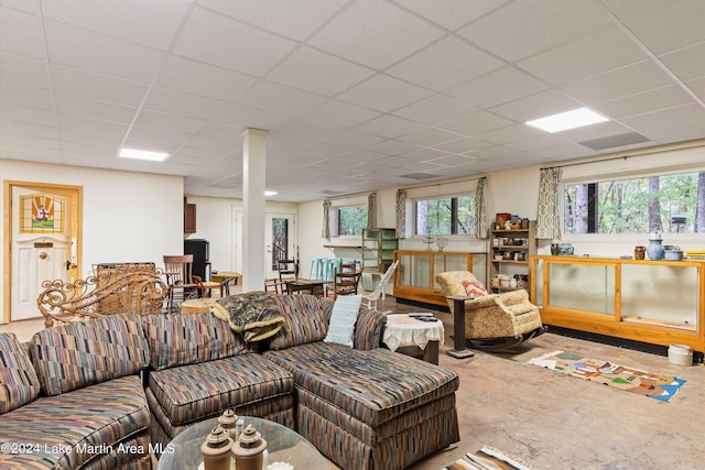 living room with a drop ceiling and concrete floors