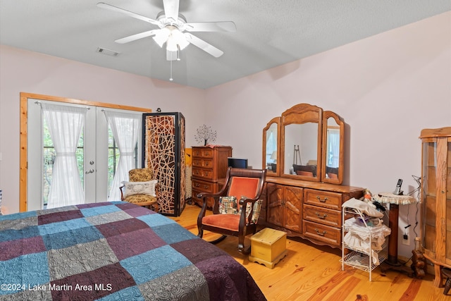 bedroom with french doors, light wood-type flooring, a textured ceiling, access to outside, and ceiling fan