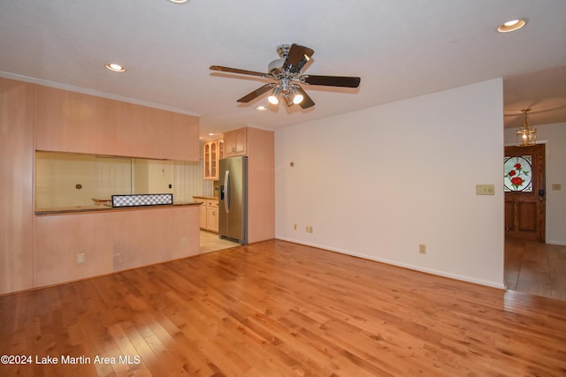 unfurnished living room featuring ceiling fan and light hardwood / wood-style flooring