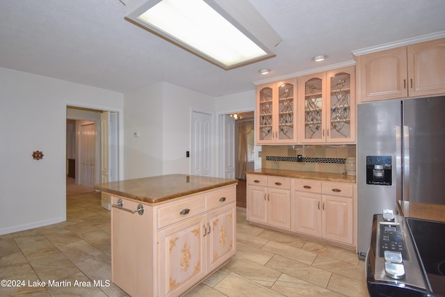 kitchen featuring tasteful backsplash, light brown cabinetry, a kitchen island, and stainless steel appliances