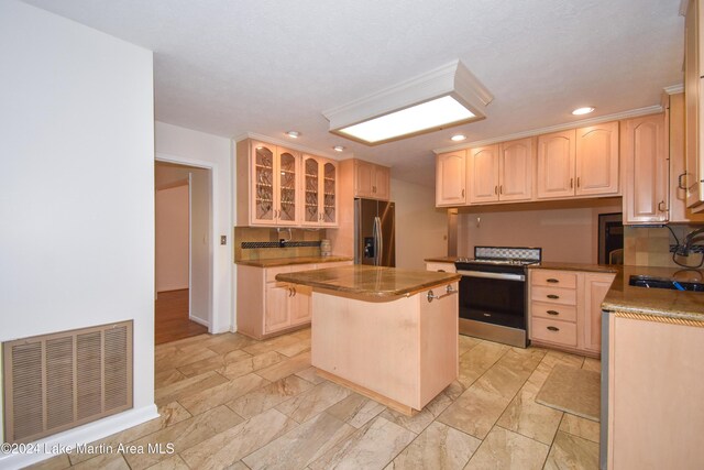 kitchen featuring a kitchen breakfast bar, light brown cabinets, a kitchen island, and appliances with stainless steel finishes