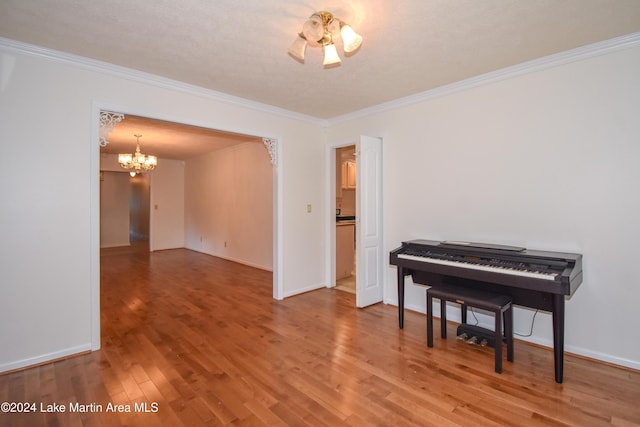 miscellaneous room with hardwood / wood-style floors, ornamental molding, a textured ceiling, and a chandelier