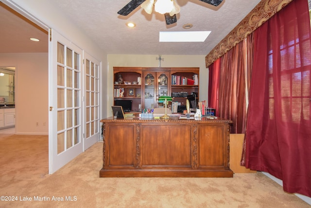 unfurnished office with sink, ceiling fan, light colored carpet, and a textured ceiling