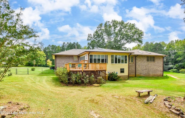 rear view of house with a yard and a deck