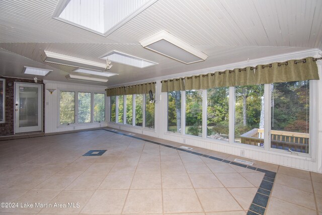 unfurnished sunroom featuring vaulted ceiling with skylight