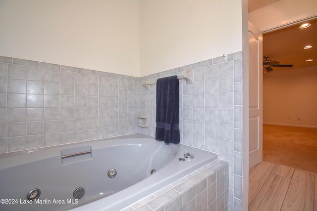 bathroom featuring ceiling fan and tiled tub