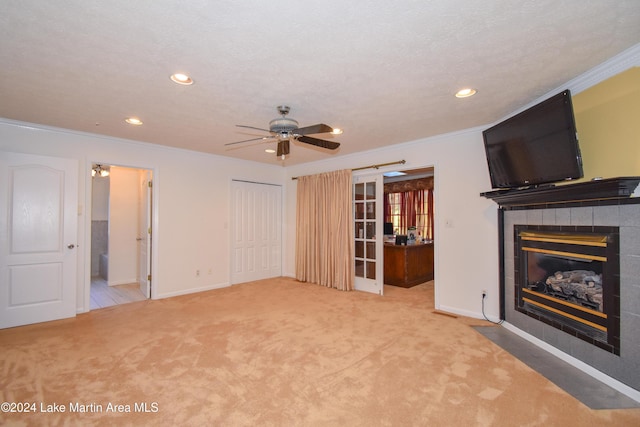 unfurnished living room with ceiling fan, crown molding, a textured ceiling, a fireplace, and carpet