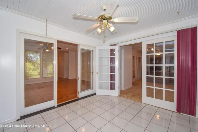 unfurnished sunroom featuring ceiling fan and french doors