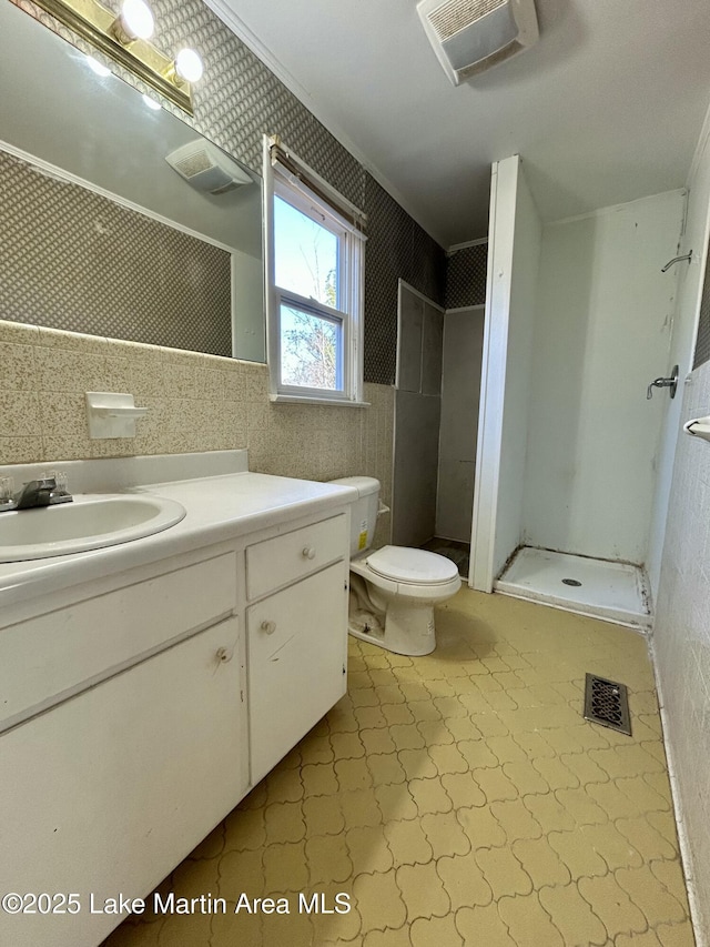 bathroom featuring toilet, vanity, crown molding, and walk in shower