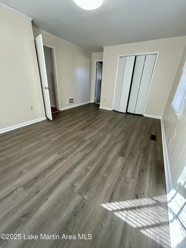 unfurnished bedroom with a closet and dark wood-type flooring