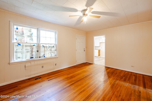 unfurnished room featuring ceiling fan, crown molding, and wood-type flooring