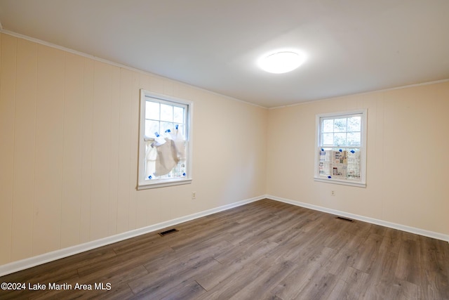 empty room featuring hardwood / wood-style floors and ornamental molding