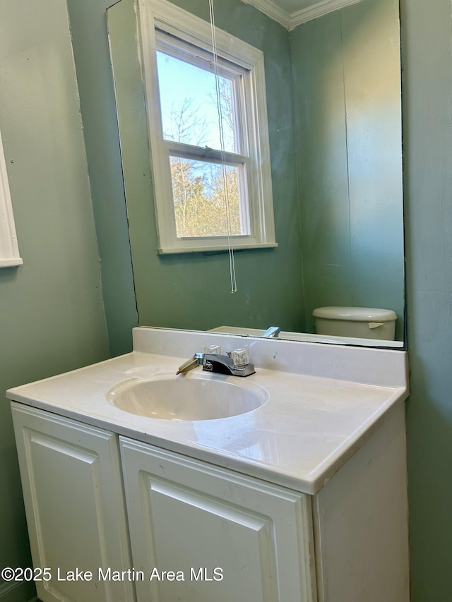 bathroom featuring ornamental molding, vanity, and toilet