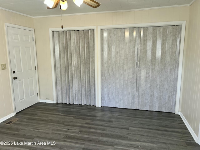 unfurnished bedroom featuring ceiling fan, ornamental molding, and dark hardwood / wood-style floors