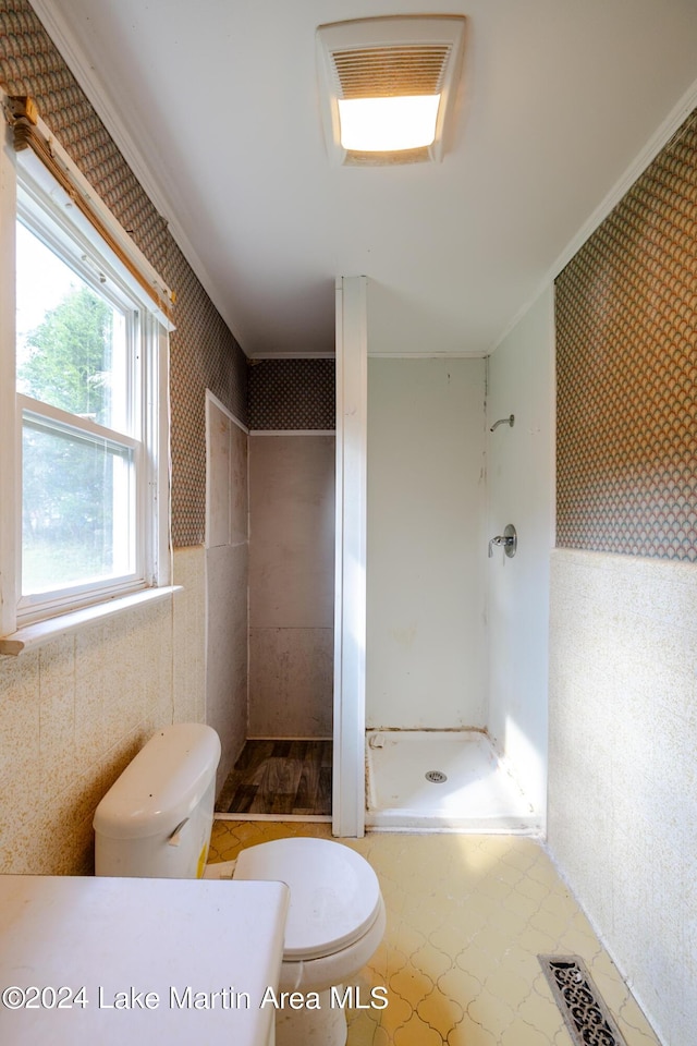 bathroom with toilet, walk in shower, and ornamental molding