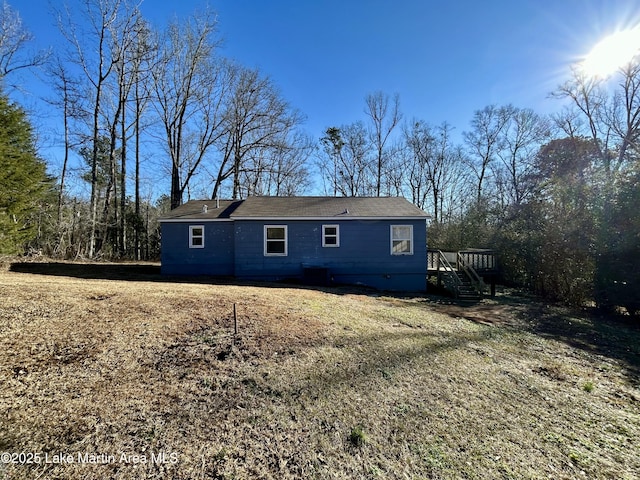 back of property with a yard and a wooden deck