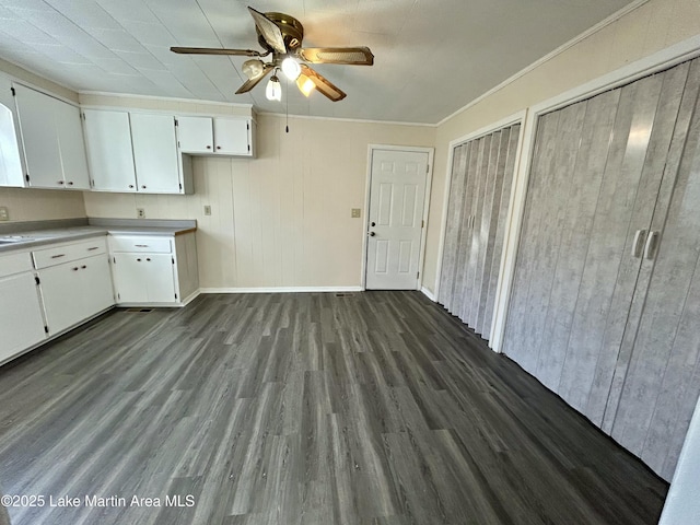 kitchen with white cabinetry, ceiling fan, crown molding, and dark hardwood / wood-style floors