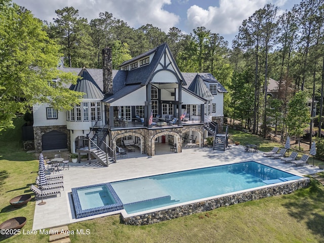 1071 Trillium W Pkwy, Eclectic, AL 36024 - rear view of house with stairs, a standing seam roof, stone siding, and a patio