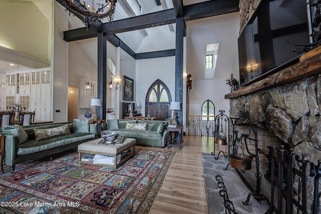 1071 Trillium W Pkwy, Eclectic, AL 36024 - living room featuring wood finished floors, beamed ceiling, a stone fireplace, high vaulted ceiling, and a notable chandelier
