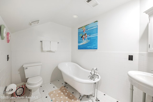 1071 Trillium W Pkwy, Eclectic, AL 36024 - bathroom featuring visible vents, lofted ceiling, a freestanding bath, and tile walls