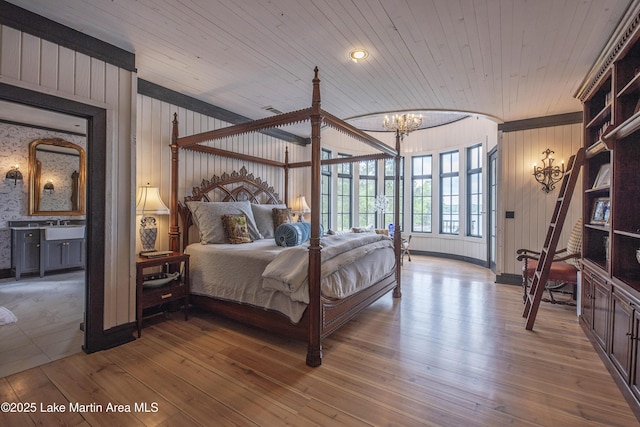 1071 Trillium W Pkwy, Eclectic, AL 36024 - bedroom featuring wooden walls, a notable chandelier, and hardwood / wood-style flooring