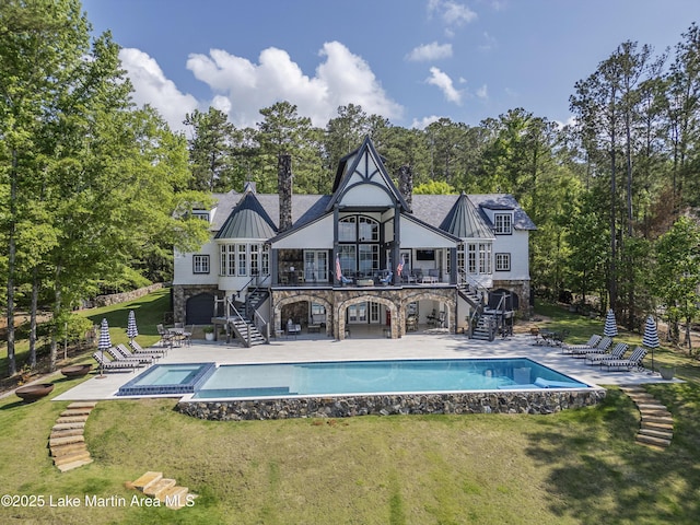1071 Trillium W Pkwy, Eclectic, AL 36024 - rear view of house featuring a standing seam roof, a patio area, stairway, a yard, and stone siding