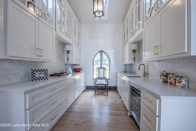 1071 Trillium W Pkwy, Eclectic, AL 36024 - kitchen featuring wood-type flooring, beverage cooler, light countertops, white cabinetry, and a sink