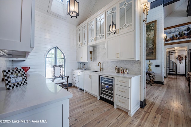 1071 Trillium W Pkwy, Eclectic, AL 36024 - kitchen with wine cooler, light countertops, light wood-style floors, and white cabinetry